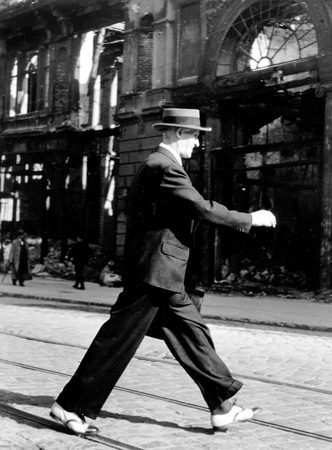 Пьер Була.
Берлин после войны: мужчина идет по улице в новых ботинках, купленных в США в 1939. 
1945. 
© Пьер Була / COSMOS